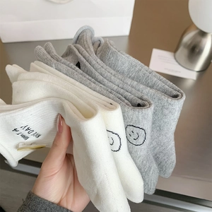 Detail of embroidered smiley face and Have a Nice Day text on soft ribbed cotton socks