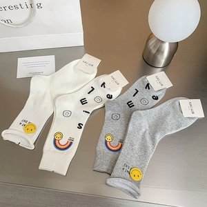 Detail of cotton crew socks featuring rainbow smile motifs and embroidered smile text