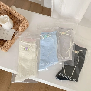 Detail of four-color cotton socks with ribbon bows and fabric flowers in gift bags