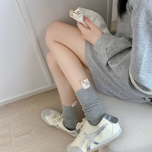 Gros plan sur des chaussettes grises côtelées avec une étiquette cœur personnalisée