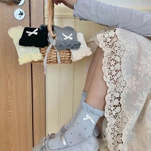 Dettaglio di calze a pois da donna con fiocco decorativo e finiture in pizzo eleganti