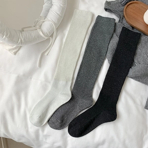 Detailed view of ballet-style glitter knit socks in white, grey, and black colors