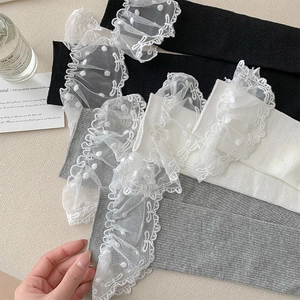 Détail de chaussettes en tricot côtelé avec bordure en dentelle noire blanche et grise