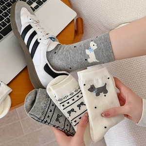Detail of grey knitted socks featuring a cute puppy embroidery and bowtie pattern