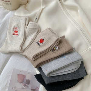 Detail of colorful knitted socks featuring cherry embroidery and cozy speckled cotton fabric