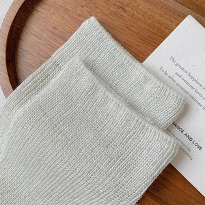 Close-up of white calf socks with silver glitter yarn showing fine knitting texture