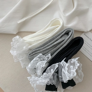 Détail de chaussettes montantes côtelées tricolores avec dentelle et tulle à pois