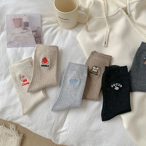 Close-up of Japanese style crew socks with cute cherry and bow embroidery details