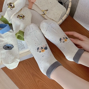 Detail of cute cartoon koala knit socks with colorful speckled patterns and ribbed cuffs