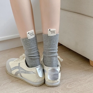 Chaussettes grises en maille côtelée avec étiquette Best Socks et baskets blanches