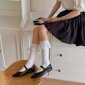 Détail de chaussettes hautes blanches en coton avec dentelle et chaussures Mary Jane