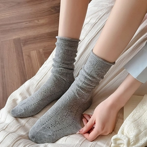 Detailed view of grey pointelle knit socks with a soft ribbed rolled edge design