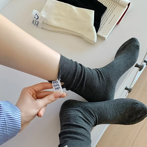 Detail of ribbed knit cotton socks with blue letter label and smiley face pattern