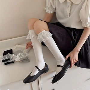 Détail de chaussettes mi-mollet japonaises blanches avec dentelle à pois et côtes verticales