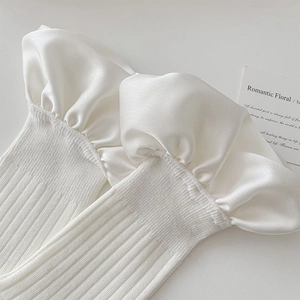 Detail of cream white ribbed knit leg warmer with elegant satin ruffle edge decoration
