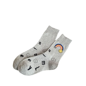 Fashionable grey crew socks featuring rainbow smiley face and knit smile letter patterns