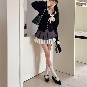 Detail of white hollow mesh breathable socks styled with black Mary Jane shoes and skirt