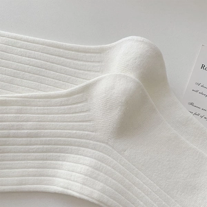 Detail of white rib-knit socks showing premium vertical stripe texture and soft cotton fabric