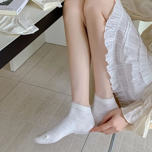 Detail of white low-cut cotton socks with heart jacquard and delicate lace trim