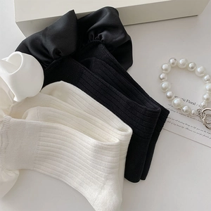Detail of ruffle trim socks in black and white with satin frills and cotton ribbing