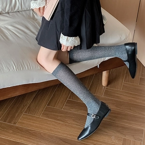 Close-up of grey glitter knee-high socks with shimmering knit texture and stylish look
