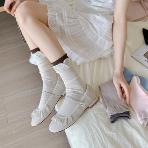 Detail of white striped crew socks with contrast trim and beaded Mary Jane shoes