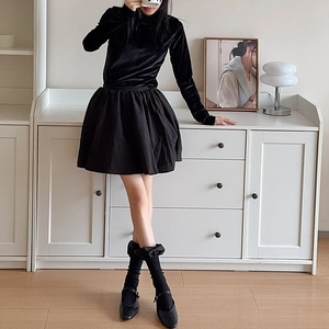 Full body view of a velvet long sleeve top and black puffy skirt with Mary Jane shoes