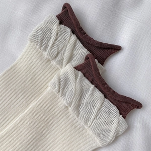 Detailed close-up of double-layer ribbed socks with lace trim and vintage brown edges