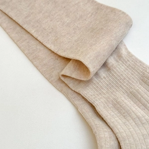 Close-up of beige ribbed knit texture on stylish knee-high socks for a soft school style