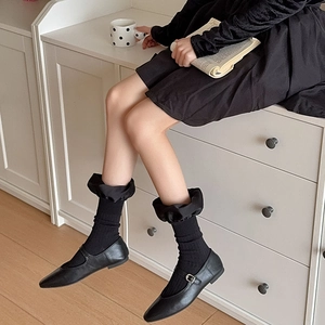 Detail of black Mary Jane shoes with vintage satin ruffle socks in high-quality lifestyle shot