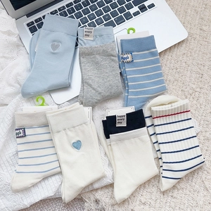 Flat lay of cotton crew socks with blue stripes, heart embroidery, and daily slogans