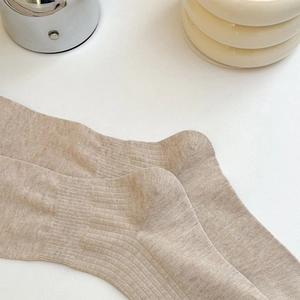 Detailed macro view of beige ribbed knit cotton socks showing premium textured fabric