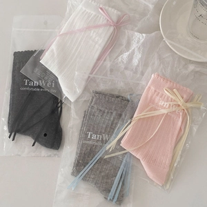 Detail showing four pairs of JK-style socks with silk ribbons in separate branded bags