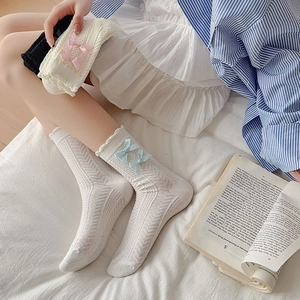 Gros plan de chaussettes style ballet avec texture chevrons et nœuds en soie rose
