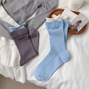 Close-up of ribbed cotton socks featuring decorative double-layered ruffled cuffs