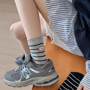 Japanese style striped crew socks in grey and black with woven label and athletic shoes
