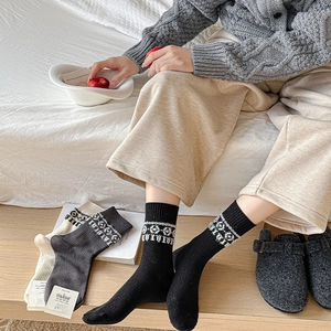 Three pairs of vintage cotton mid-calf socks in black, grey, and white with Nordic patterns