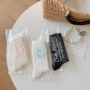 Vue détaillée de chaussettes style ballerine avec nœuds et maille torsadée emballées