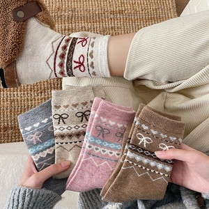 Détail de chaussettes en laine avec motifs Fair Isle en coloris crème, rose, gris et brun