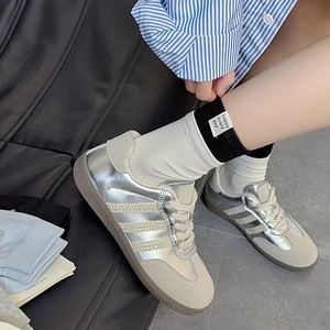 Close-up of metallic silver sneakers with suede panels and retro gum rubber sole