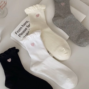 Detail of sweet cotton socks with ruffled edges and pink heart embroidery in four colors