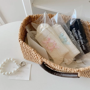 Détail de trois paires de chaussettes à nœuds style ballet dans un panier tressé