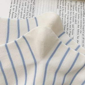 Close-up of cream and blue striped knit socks on vintage book background
