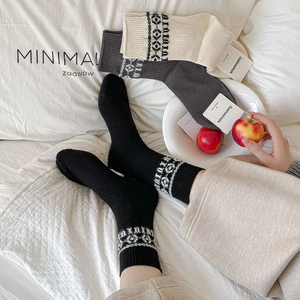 Three pairs of vintage knit mid-calf socks in black, grey and beige with geometric patterns