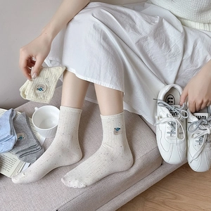 Close-up of knit crew socks with cute bear embroidery and colorful flecked texture