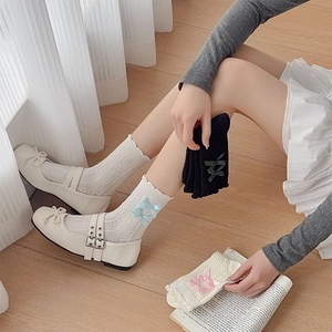 Détail de chaussettes style ballerine avec bords ondulés et nœuds sous une lumière douce