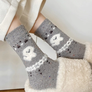 Close-up of wool socks with knit ghost patterns and speckled yarn texture for winter