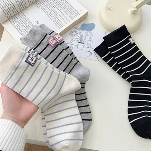 Detailed close-up of striped cotton socks with decorative labels in soft aesthetic setting
