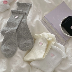 Close-up of sweet heart embroidery and ruffled lace edge on soft cotton socks