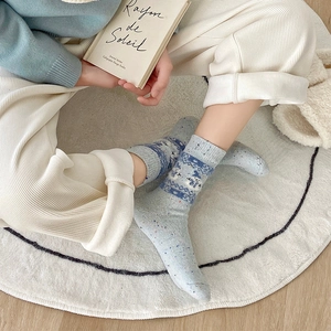 Close-up of Fair Isle wool socks featuring blue jacquard patterns and cute winter motifs